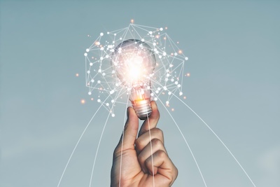 A hand holding a light bulb Lifted up in the sky outdoors